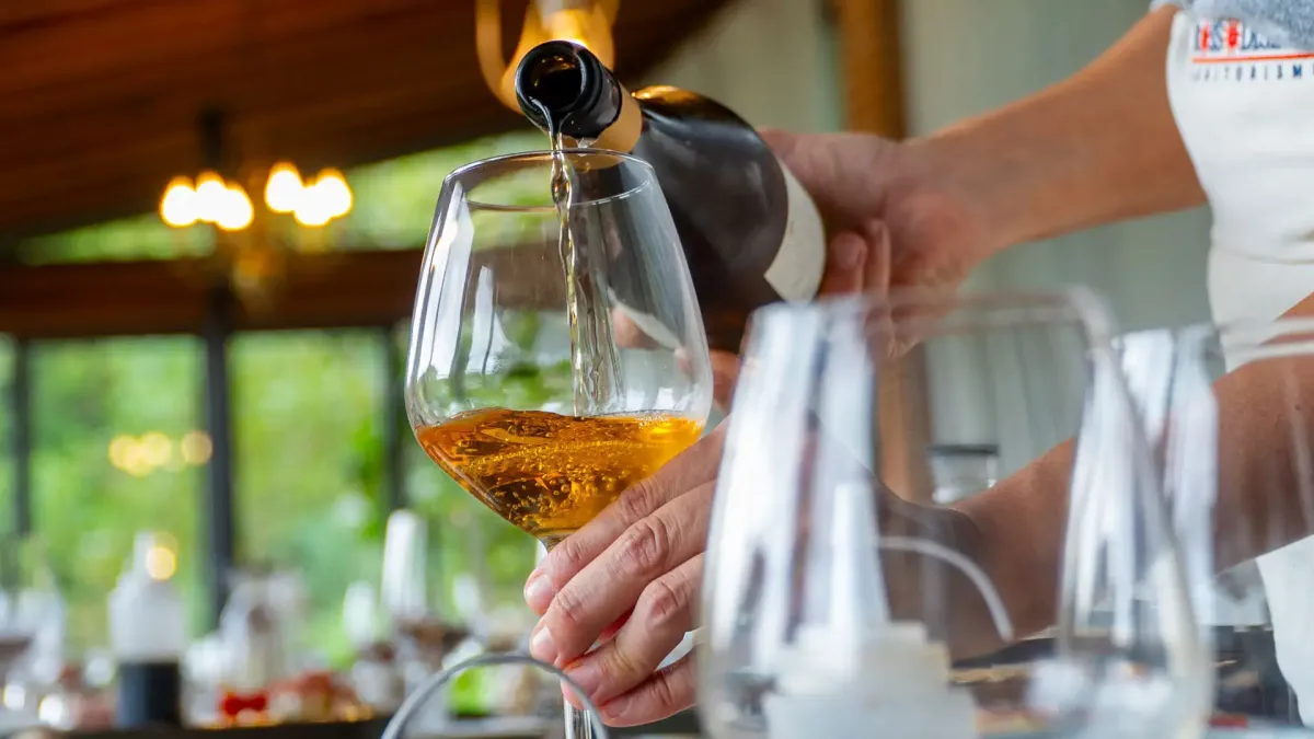 vino versato nel calice da chef per brunch